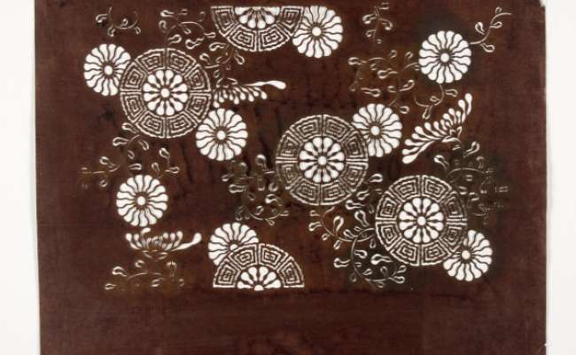 Katagami stencil with a design of carriage wheels (emblematic of classical culture) containing stylised chrysanthemum heads within a geometric border
