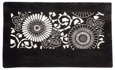 Katagami stencil depicting stylised chrysanthemums, an Autumnal flower, against a  background of scrolling stems